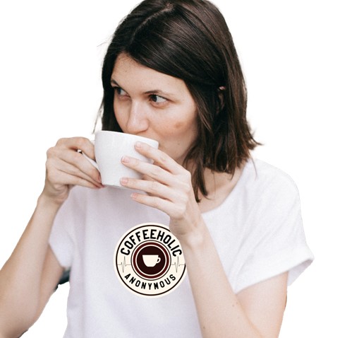 woman drinking coffee and wearing the coffee anonymous design on a white t-shirt